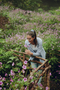 Adorable brunette in a rain forest with a flowers all around