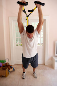Man pulling resistance band at home