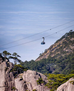 Low angle view of overhead cable car against sky