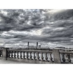 Railing against cloudy sky