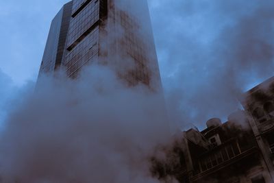 Low angle view of modern buildings in city against sky