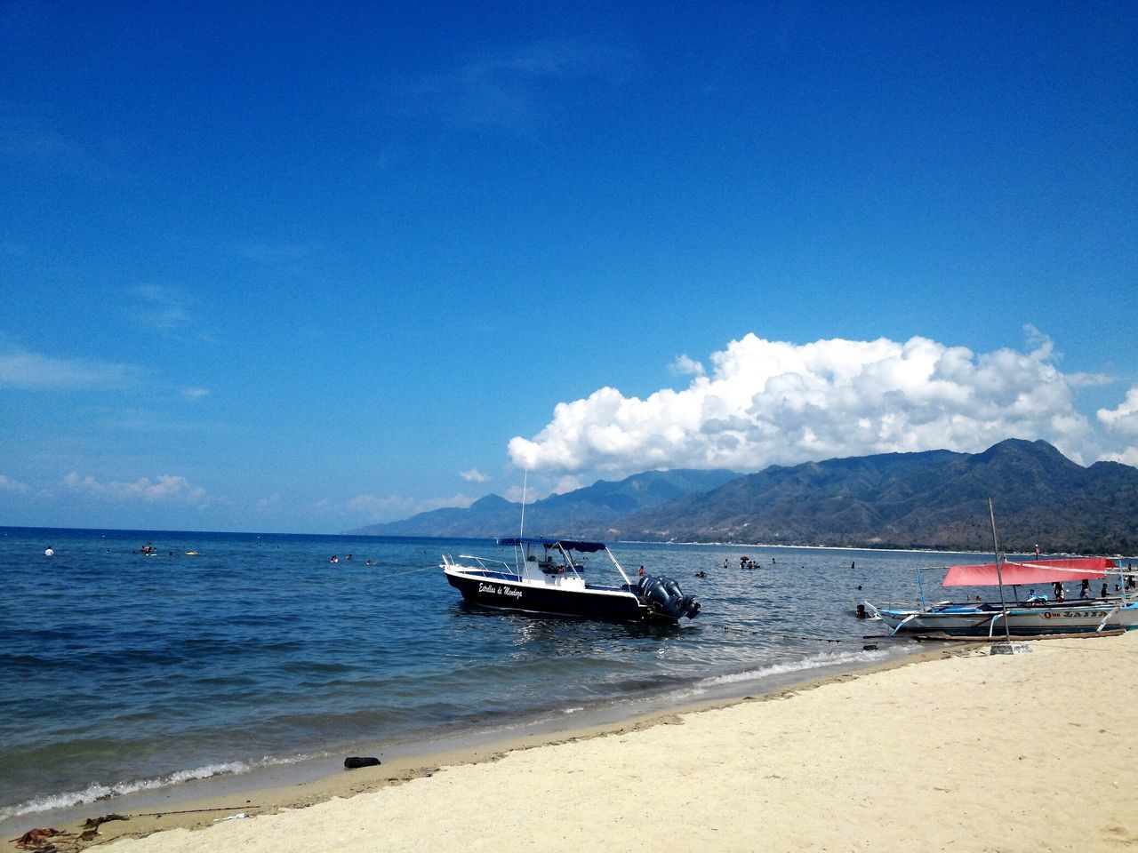 nautical vessel, transportation, sea, water, mode of transport, sky, boat, beach, moored, tranquil scene, tranquility, shore, sand, scenics, beauty in nature, cloud - sky, blue, mountain, nature, cloud