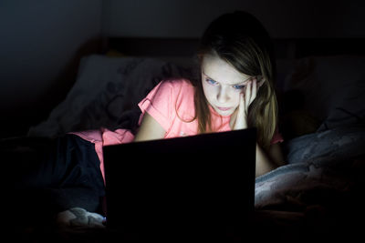 Close-up of senior woman using laptop on bed at home