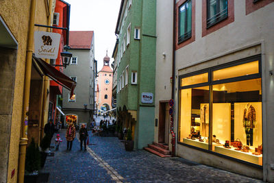 People walking on alley in town at dusk