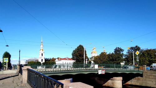 View of bridge over canal against clear blue sky