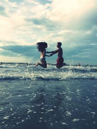 People enjoying in sea against sky