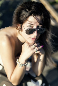 Portrait of woman holding sunglasses