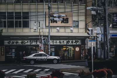 Cars on road by buildings in city