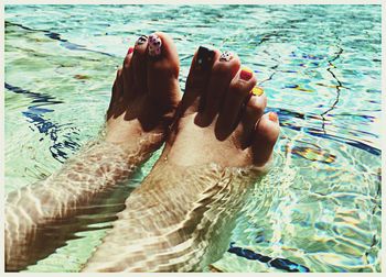 Close-up of bare feet in swimming pool