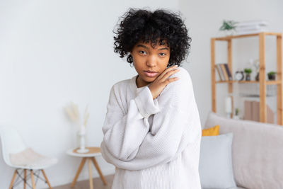 Portrait of young woman sitting on sofa at home