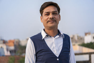 Portrait of man standing against sky