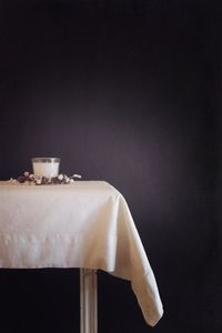 Glass of drink on table against wall