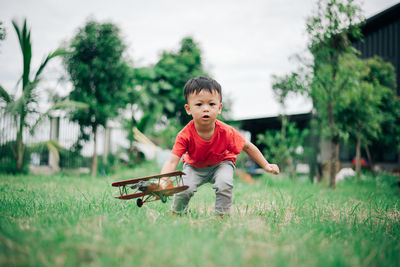 Full length of cute boy playing with toy on field