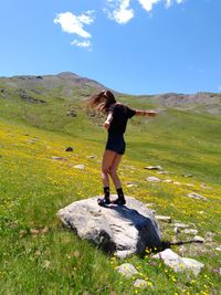 Full length of woman standing on mountain against sky