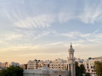 Buildings in city against cloudy sky