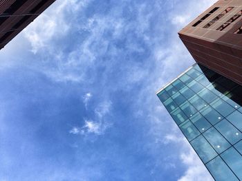 Low angle view of modern building against cloudy sky