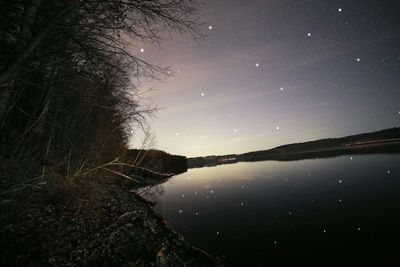 Scenic view of lake against sky at night