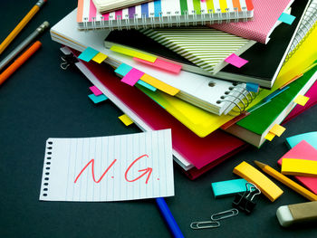 High angle view of text on paper with books at desk