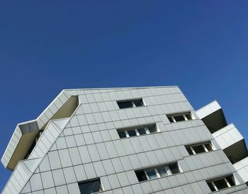 Low angle view of modern building against clear blue sky