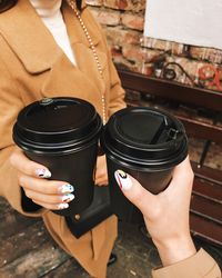 Midsection of woman holding coffee cup reflecting in mirror