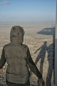 Rear view of woman standing at desert