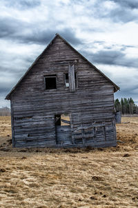 Old house on field against sky