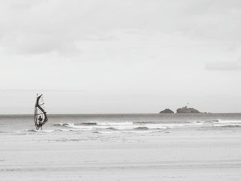 Silhouette on beach against sky