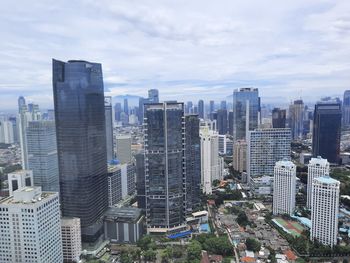 Aerial view of buildings in city against sky