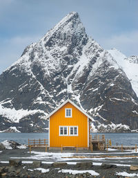 Yellow house against snowcapped mountain