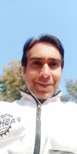 Portrait of smiling young man against sky