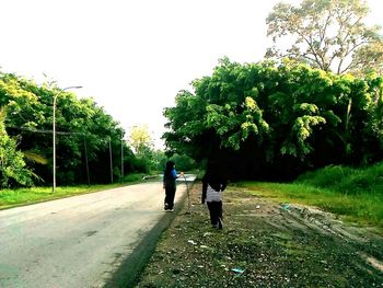 Rear view of men walking on road