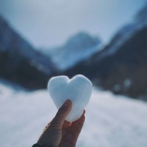Close-up of hand holding heart shape during winter