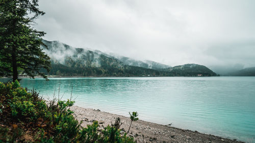 Scenic view of lake by mountains against sky
