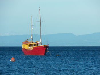 Ship moored on sea against clear sky