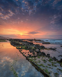 Scenic view of beach against sky during sunset