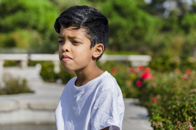 Young man standing against plants