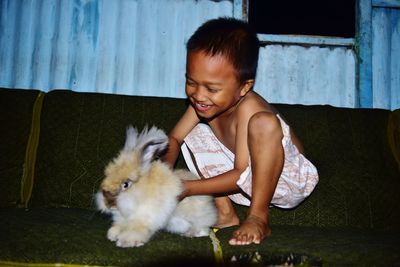 Cheerful boy playing with rabbit