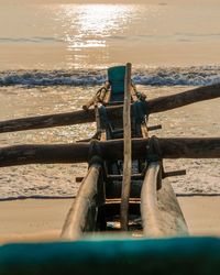 Deck chairs on beach against sky during sunset