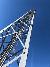 Low angle view of communications tower against clear blue sky