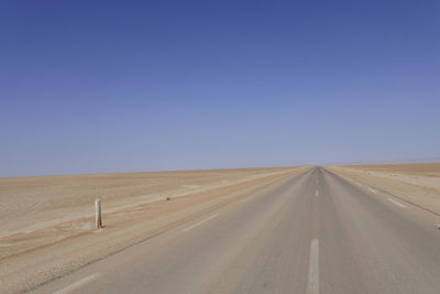 Empty road along countryside landscape