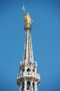 View to spires and statues on roof of duomo through ornate marble fencing. milan, italy