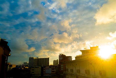 Low angle view of city against sky during sunset