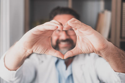 Portrait of man making heart shape