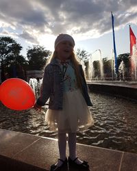 Portrait of girl standing against sky