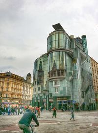 Buildings in city against cloudy sky