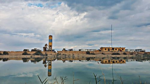 Reflection of building in lake against sky