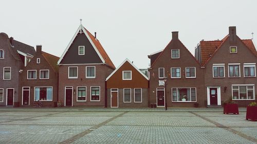 Houses by street against sky