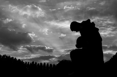 Low angle view of silhouette statue against sky