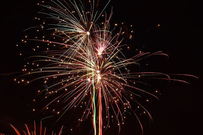 Low angle view of firework display against sky at night