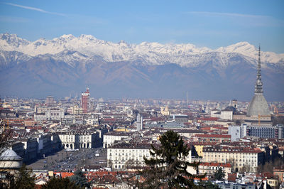 Aerial view of townscape and mountains against sky